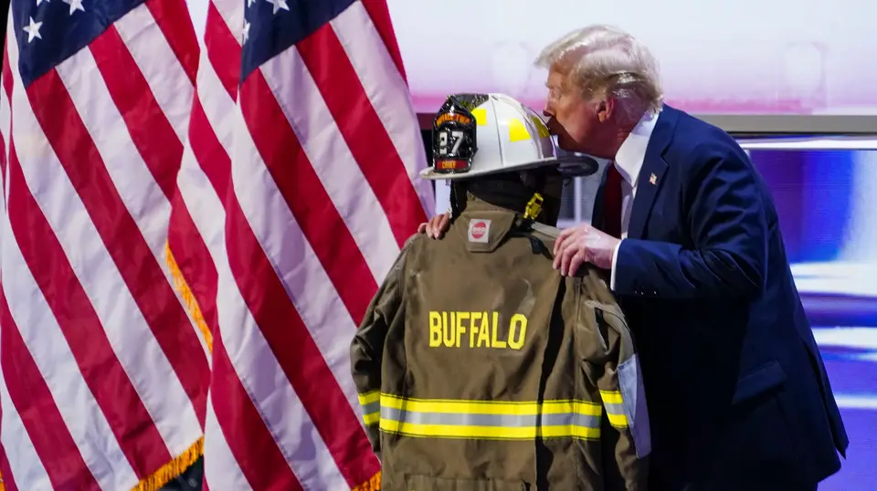 O fato e o capacete do bombeiro assassinado foram colocados no palco enquanto Trump falava.