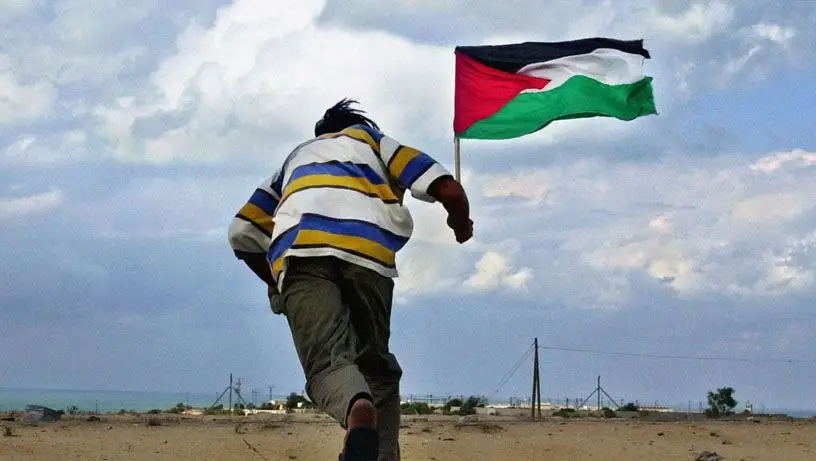 Palestiniano corre com bandeira em Khan Yunis