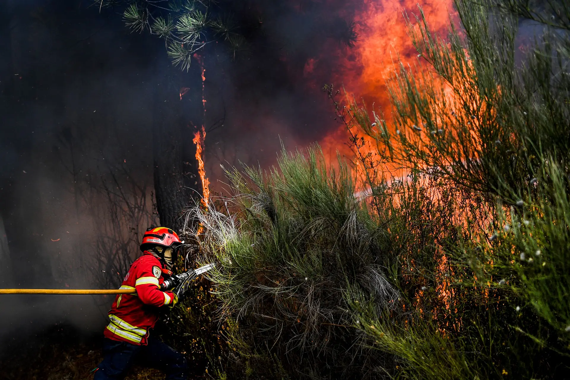Um bombeiro combate um incêndio perto de Manteigas