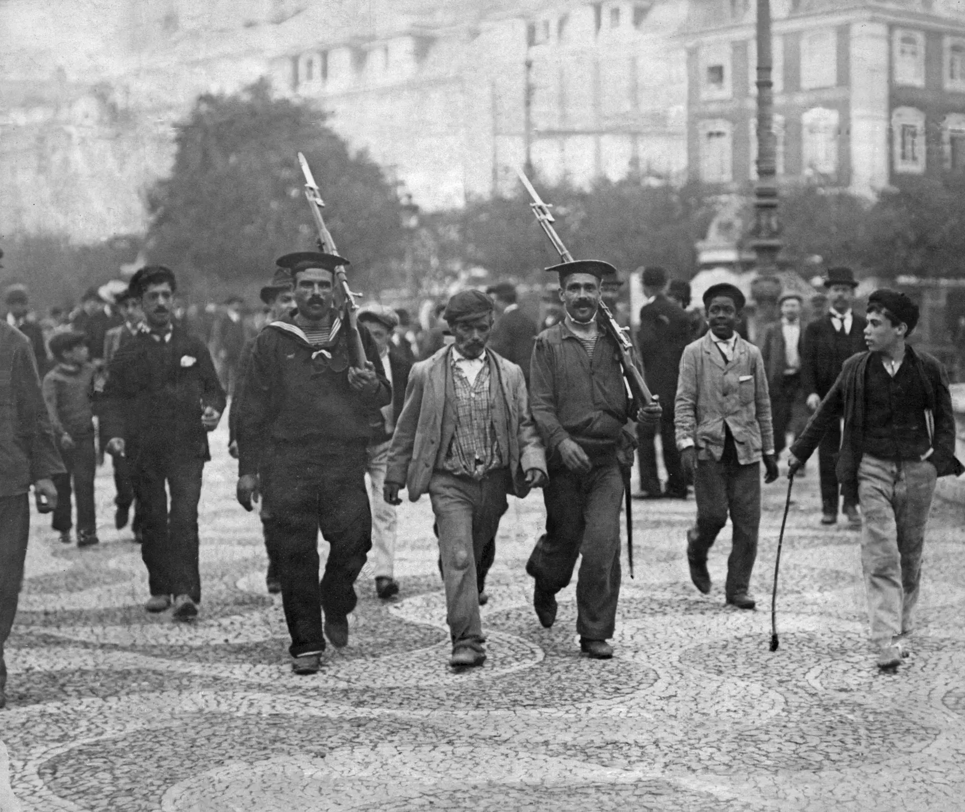 Marinheiros portugueses escoltam um prisioneiro monárquico pelas ruas de Lisboa na sequência dos combates entre as forças republicanas e monárquicas, a 5 de Outubro de 1910.
