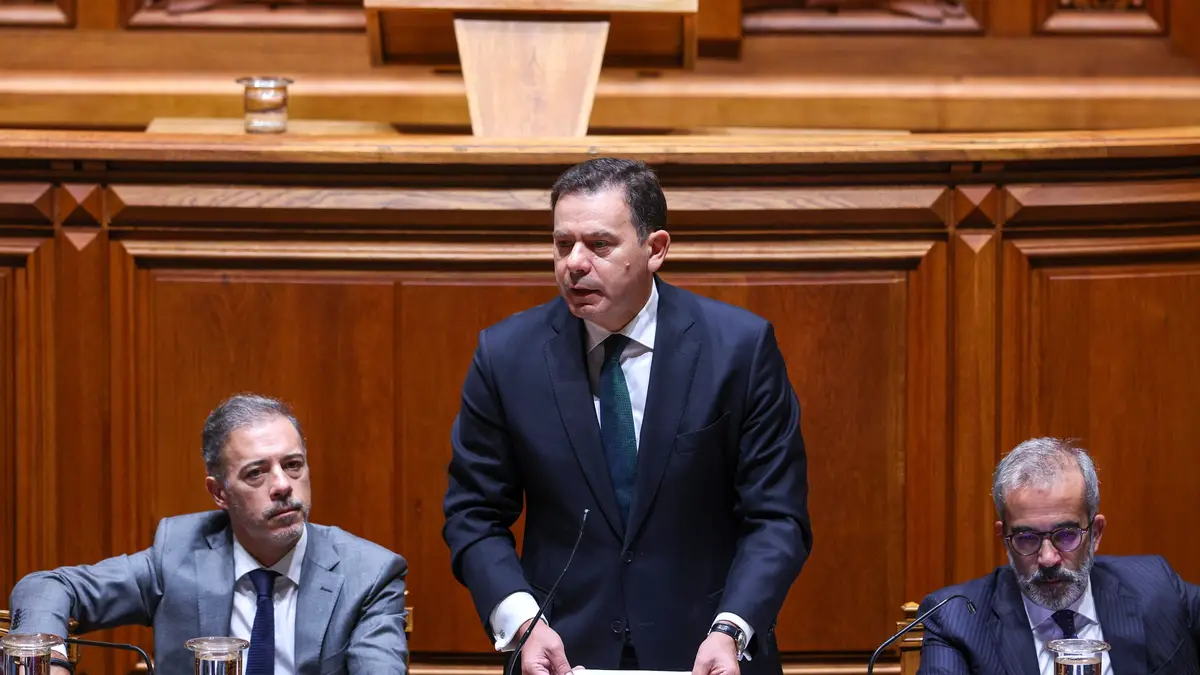 O primeiro-ministro, Luís Montenegro (C), ladeado pelo ministro dos Assuntos Parlamentares, Pedro Duarte (E), e pelo ministro de Estado e dos Negócios Estrangeiros, Paulo Rangel (D), intervém no debate parlamentar preparatório do Conselho Europeu na Assembleia da República, em Lisboa