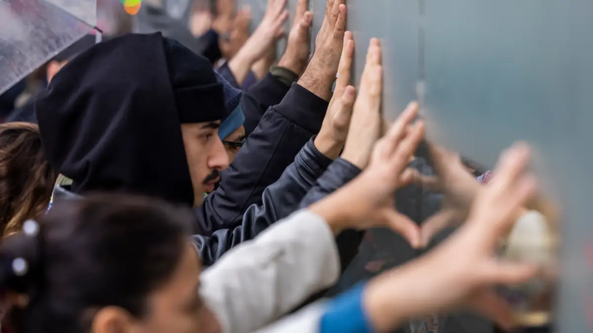 Ativistas encostam-se à parede na Avenida de Roma para denunciar operação policial no Martim Moniz