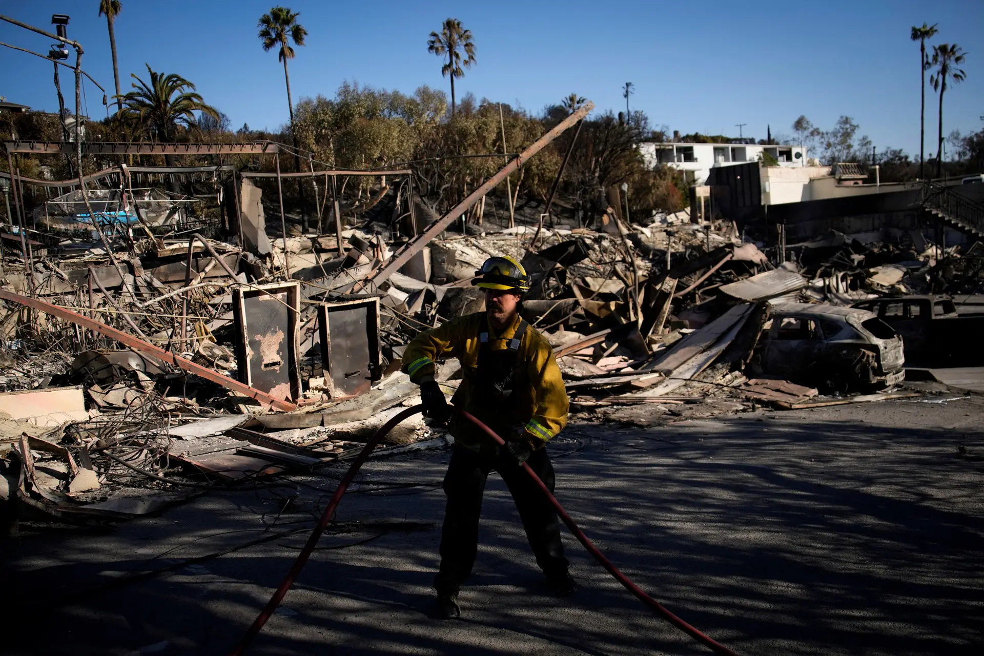 Bombeiro numa área área devastada pelo fogo após o incêndio Palisades, no bairro Pacific Palisades, em Los Angeles.
