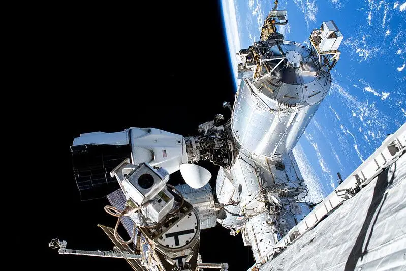 A astronauta Suni Williams (ao centro) perto da nave espacial SpaceX Dragon acoplada à ISS, a 16 de janeiro de 2025