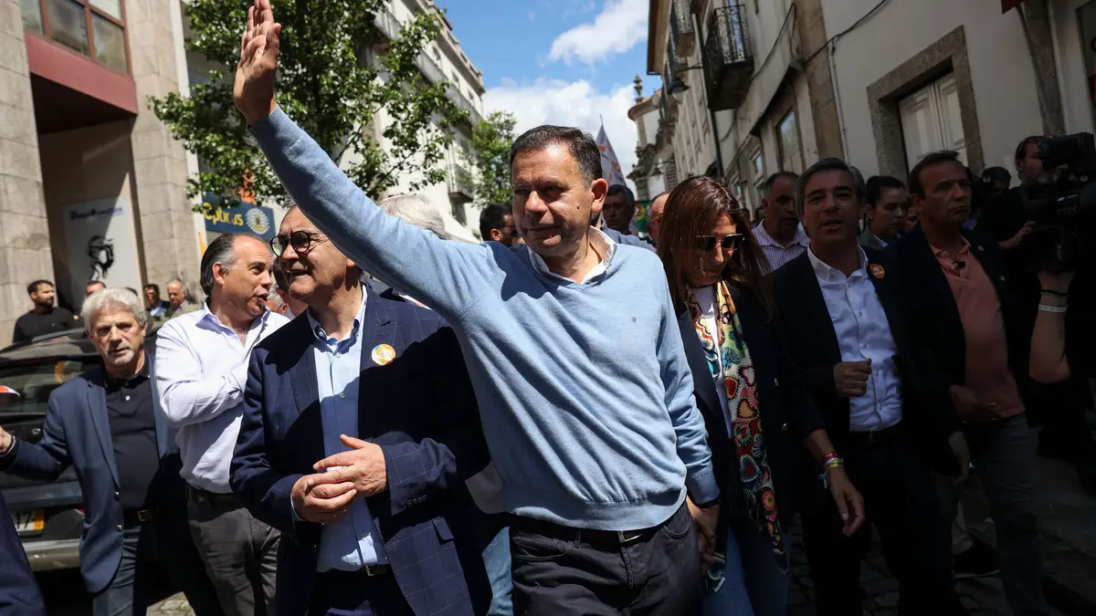 O Primeiro-Ministro e Presidente do Partido Social Democrata (PSD), Luís Montenegro (C), acena para os cidadãos em uma marcha como parte da campanha da Aliança Democrática (AD) para as próximas eleições legislativas em Arcos de Valdevez, Portugal, 14 de maio de 2025.