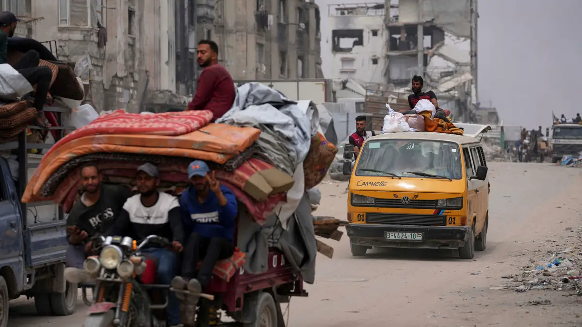 Palestinianos deslocados que fogem de Beit Lahia no meio das operações militares israelitas em curso na Faixa de Gaza chegam a Jabalia, no norte de Gaza, no domingo, 18 de maio de 2025.
