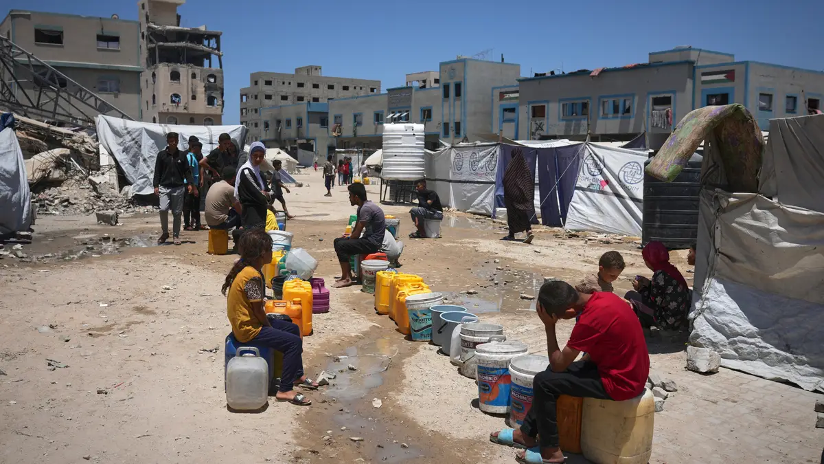 Crianças palestinianas esperam na fila para recolher água na Cidade de Gaza, sábado, 24 de maio de 2025.