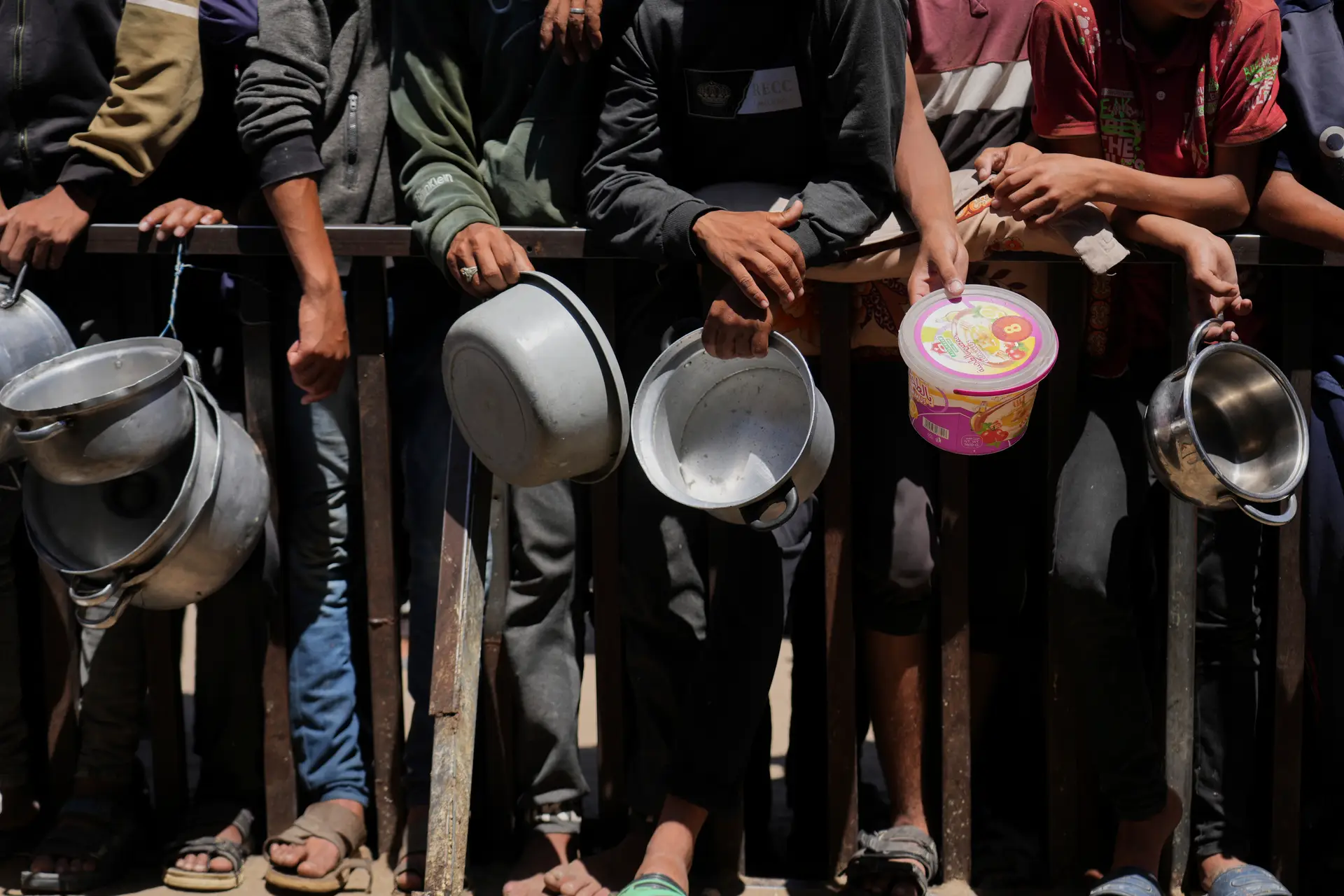 Palestinianos esperam para receber comida doada numa cozinha comunitária em Khan Younis, no sul da Faixa de Gaza, segunda-feira, 2 de junho de 2025. 