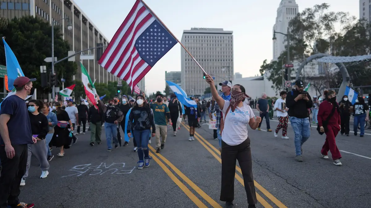 Uma mulher segura uma bandeira americana durante um protesto na terça-feira, 10 de junho de 2025, em Los Angeles.
