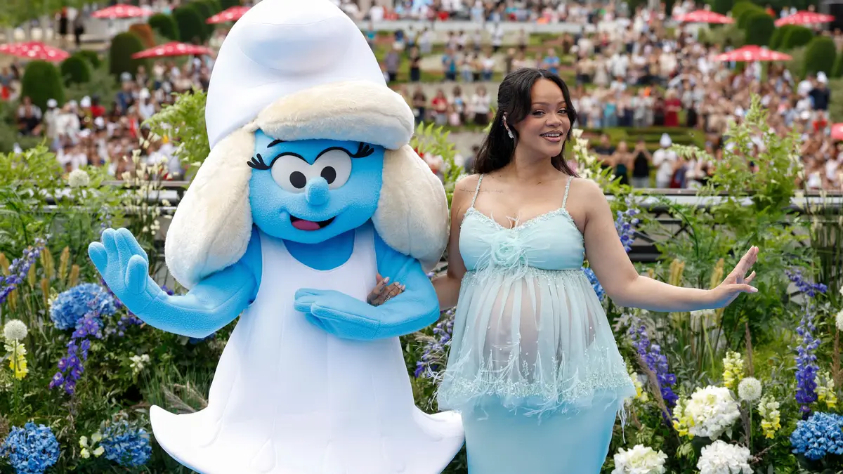 Rihanna posa com uma pessoa fantasiada de Smurfette para os fotógrafos na chegada à estreia mundial do filme "Smurfs", no sábado, 28 de junho de 2025, em Bruxelas.     Ask ChatGPT