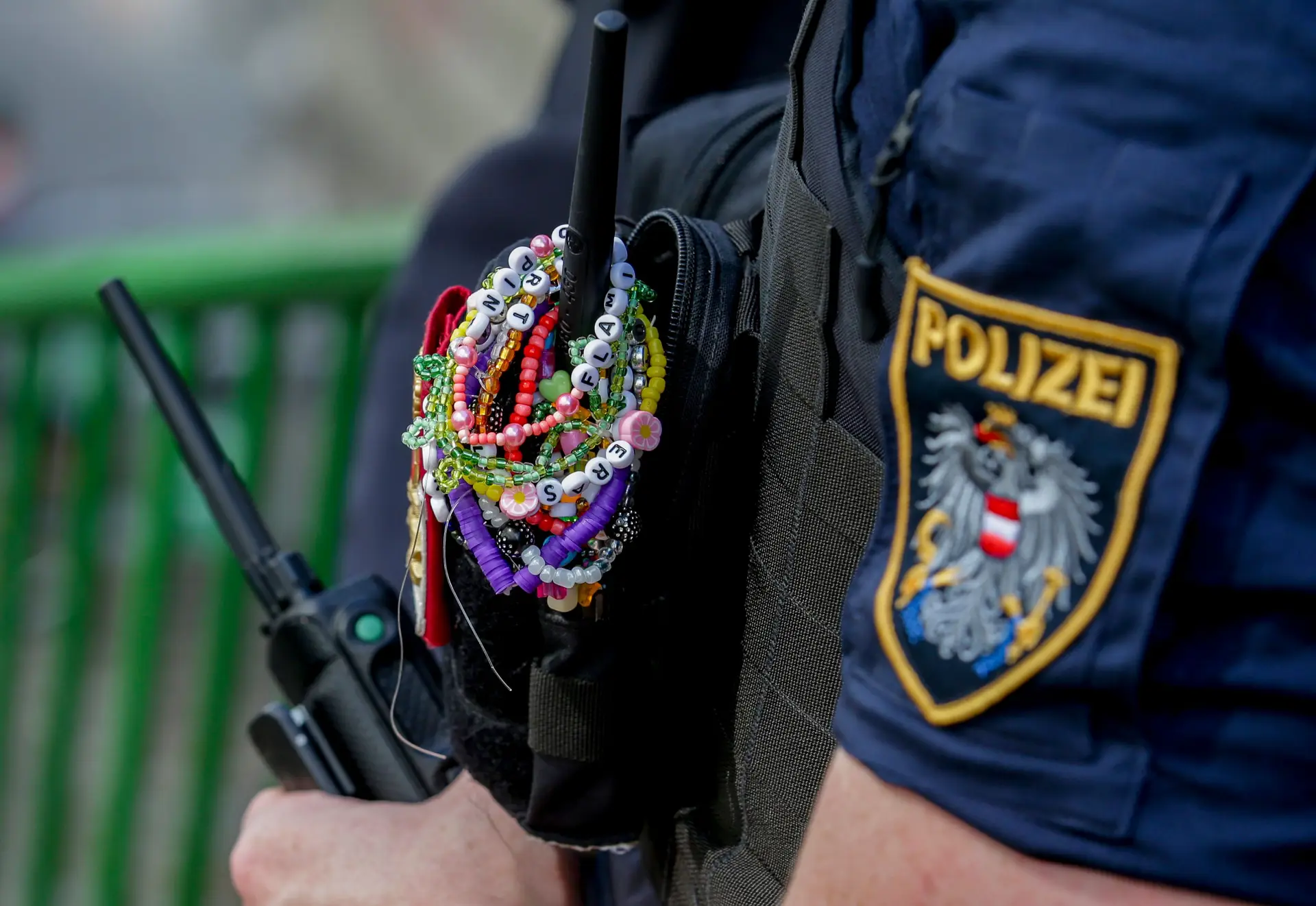 Um agente da polícia exibe pulseiras da Taylor Swift enquanto patrulha o centro da cidade de Viena, a 8 de agosto de 2024.