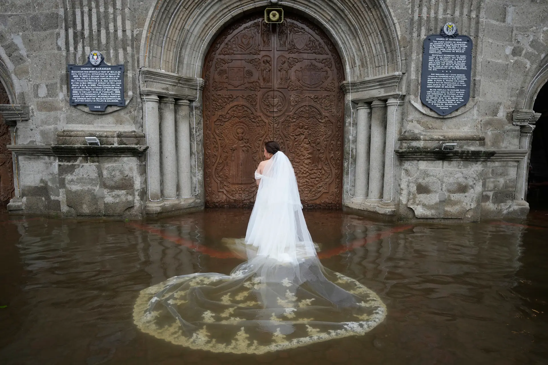 A noiva, Jamaica Aguilar, prepara-se para entrar na igreja de Barasoain, inundada, para o seu casamento em Malolos, na província de Bulacan, Filipinas, na terça-feira, 22 de julho de 2025.