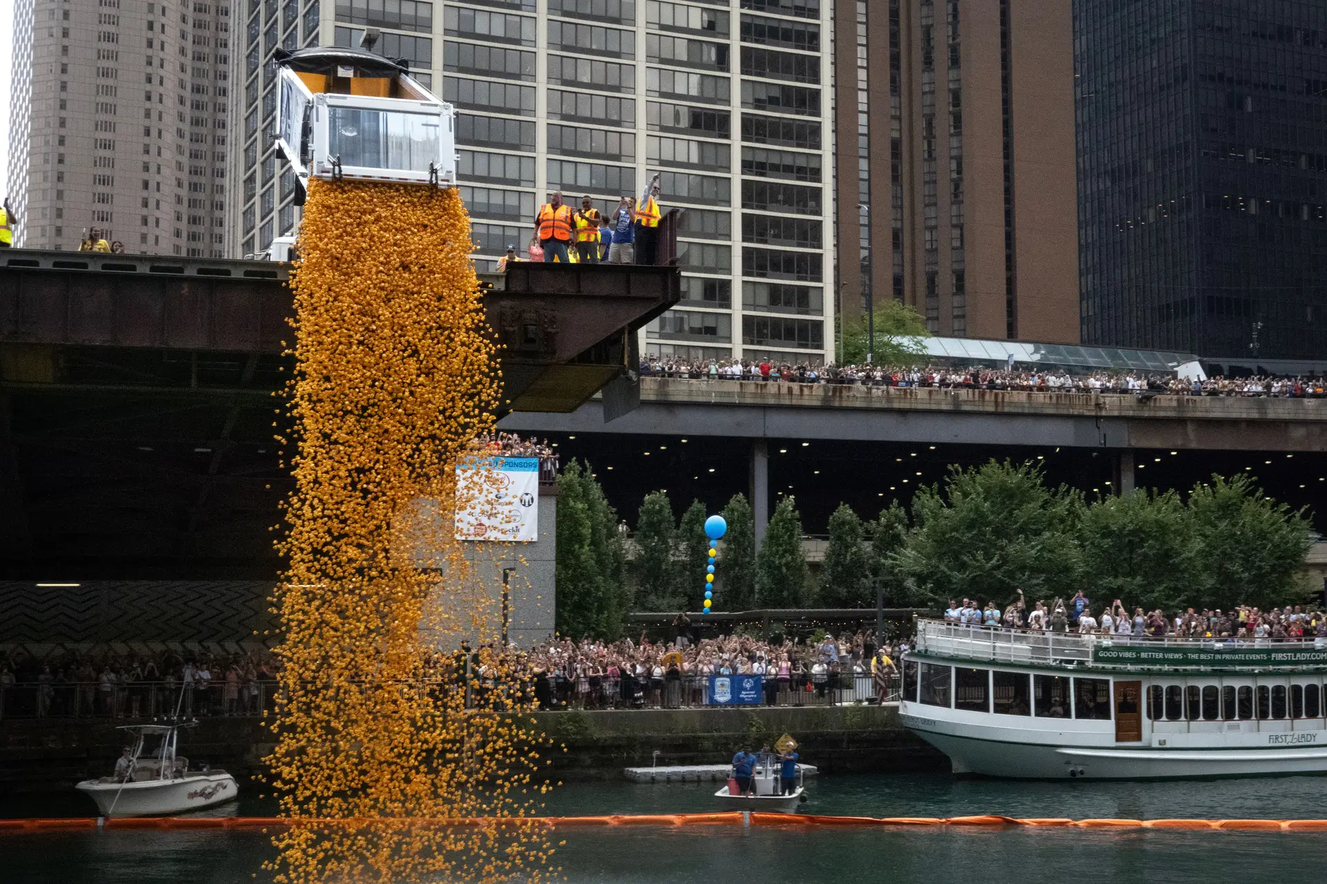 Pessoas observam enquanto patinhos de borracha são lançados no rio Chicago, onde irão competir até à linha de chegada durante uma angariação de fundos solidária, a 7 de agosto de 2025, em Chicago, Illinois.