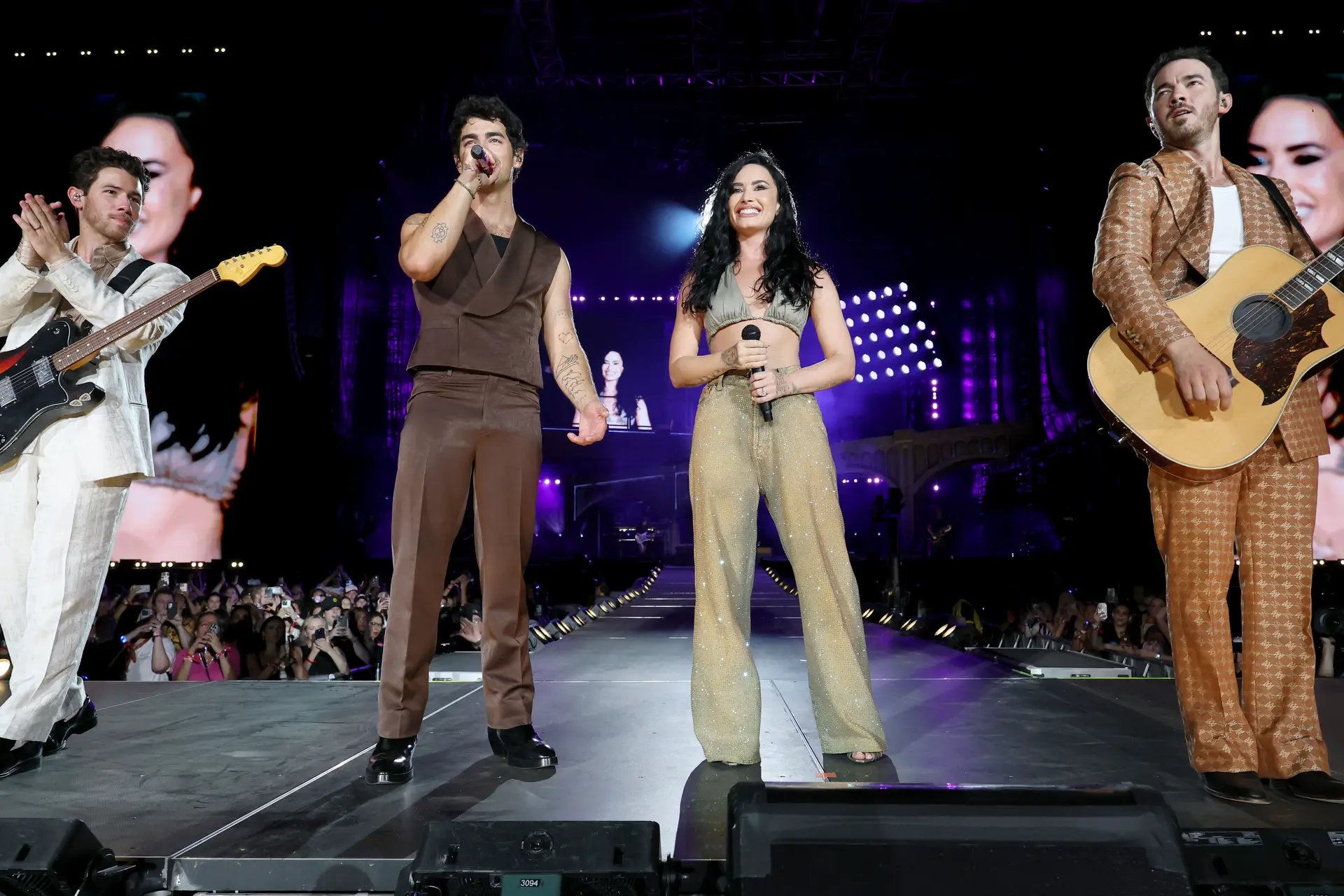 Nick Jonas, Joe Jonas, Demi Lovato e Kevin Jonas atuam no palco durante o arranque da digressão Jonas Brothers: JONAS20 – Greetings From Your Hometown, no MetLife Stadium, a 10 de agosto de 2025, em East Rutherford, Nova Jérsia.