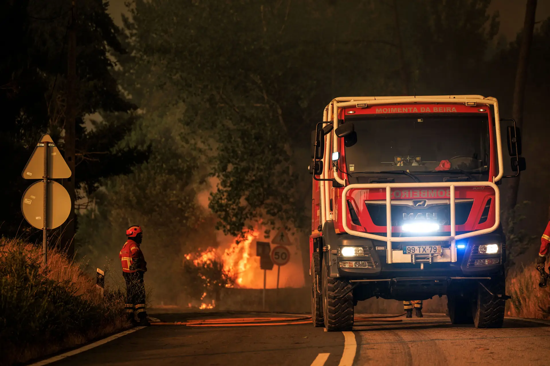 Bombeiros no local enquanto um incêndio florestal deflagra em Granja do Paiva, no concelho de Sernancelhe, distrito de Viseu, Portugal, a 14 de agosto de 2025.