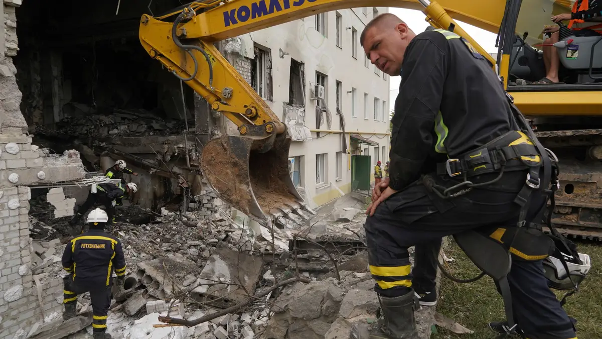 Os trabalhadores de resgate removem os escombros de um edifício residencial danificado por um ataque russo em Kharkiv, Ucrânia, segunda-feira, 18 de agosto de 2025.