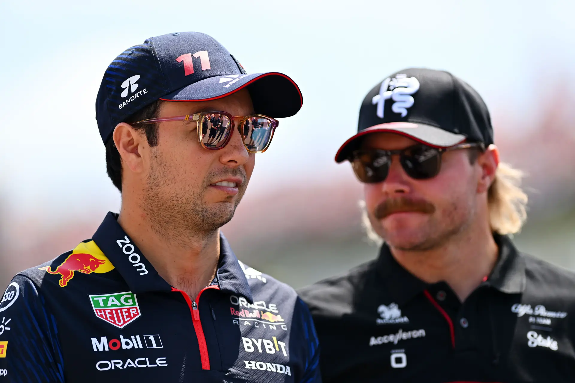 Sergio Pérez, do México, e da equipa Oracle Red Bull Racing, com Valtteri Bottas, da Finlândia, e da equipa Alfa Romeo F1, durante o desfile dos pilotos antes do Grande Prémio da Hungria, no Hungaroring, em 23 de julho de 2023, em Budapeste, Hungria.