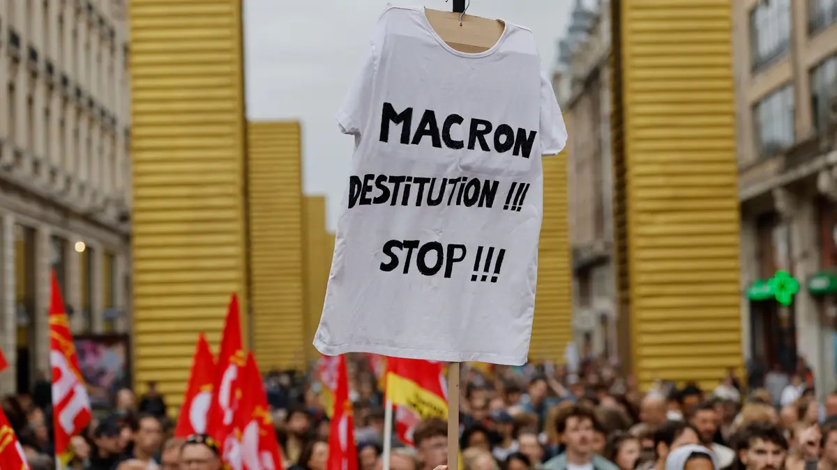Um manifestante segura um cartaz que diz: 'Removam Macron agora!! Parem!!' durante um protesto do movimento 'Bloquear Tudo' em Lille, no norte de França, na quarta-feira, 10 de setembro de 2025.
