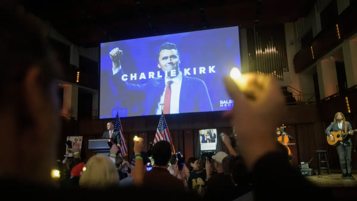 Pessoas seguram velas e cantam durante uma vigília de oração e homenagem a Charlie Kirk no Centro Memorial John F. Kennedy para as Artes Performativas, no domingo, 14 de setembro de 2025, em Washington.