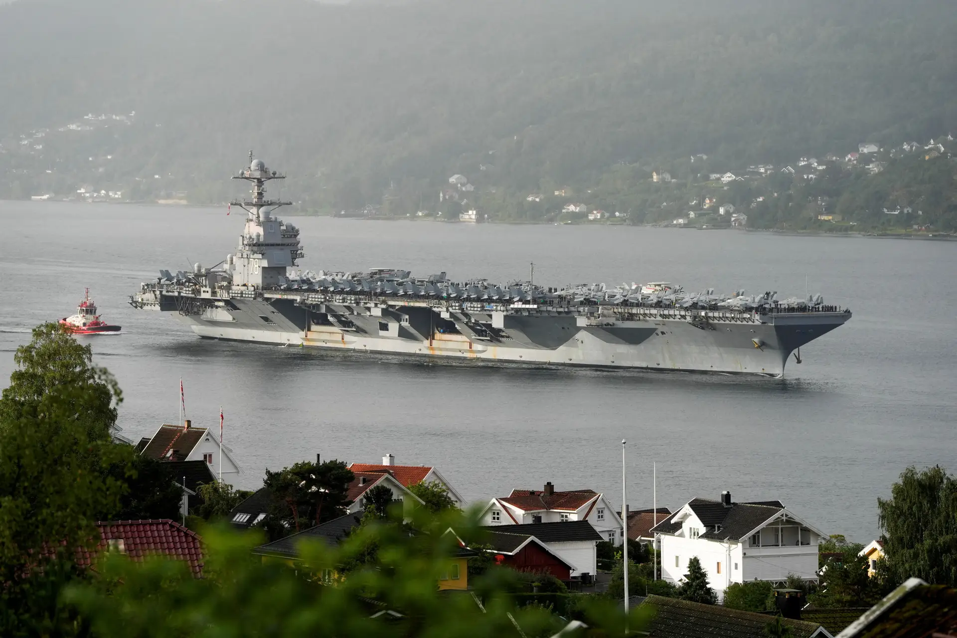 O porta-aviões USS Gerald R. Ford ao largo de uma cidade na Noruega