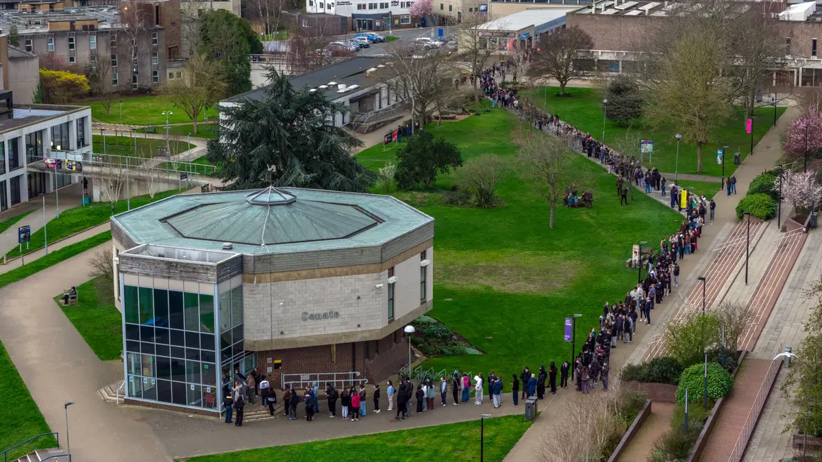 Funcionários e estudantes fazem fila na Universidade de Kent, em Canterbury, para receber antibióticos, após um surto de meningite que provocou a morte de estudantes, em 16 de março de 2026, em Canterbury, Reino Unido.