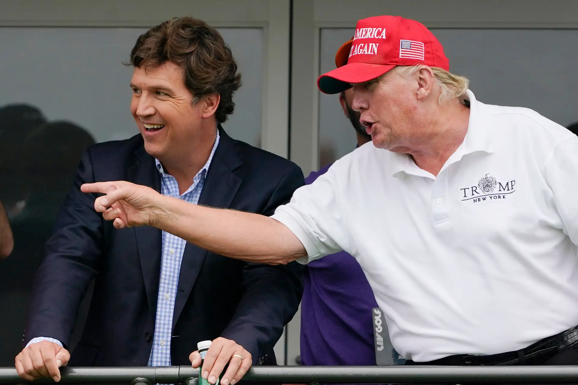 À esquerda, Tucker Carlson, e Donald Trump, à direita, durante a ronda final do LIV Golf Invitational no Trump National, em Bedminster, Nova Jérsia, a 31 de julho de 2022